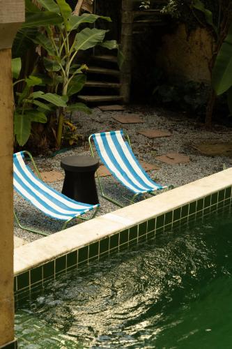 two lawn chairs sitting next to a body of water at O Portalzinho in Paraty