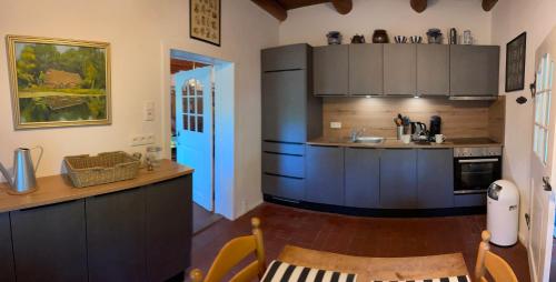 Una cocina con gabinetes de color azul oscuro y un fregadero. en Reetdachhaus am See Ostfriesland, en Leezdorf