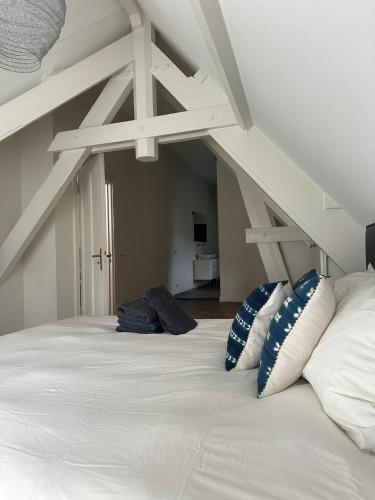 a large white bed with pillows in a room at Urban Comfort Loft in The Hague