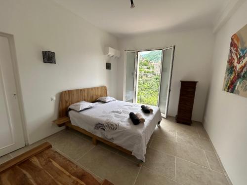 une chambre avec un lit et une grande fenêtre dans l'établissement Très bel appartement dans Maison, à Saorge