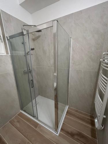 une douche avec une porte vitrée dans une salle de bain dans l'établissement Très bel appartement dans Maison, à Saorge