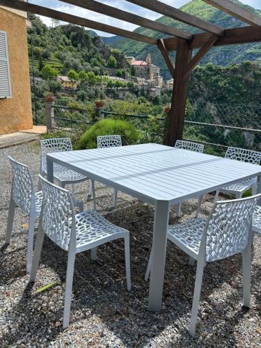 une table et des chaises blanches avec vue dans l'établissement Très bel appartement dans Maison, à Saorge