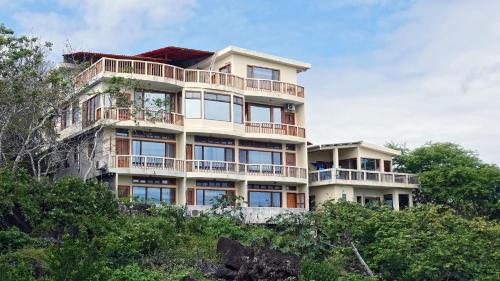 a building on top of a hill with trees at The Galeodan Suites in Puerto Baquerizo Moreno
