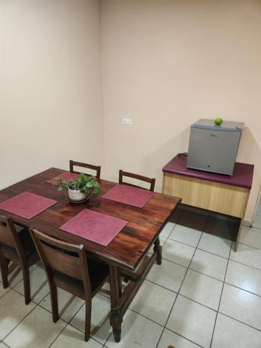a wooden table with two chairs and a television at A pasos del MOVISTAR ARENA in Santiago