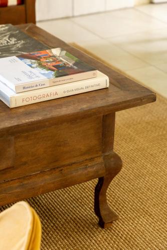 two books sitting on top of a wooden table at O Portalzinho in Paraty