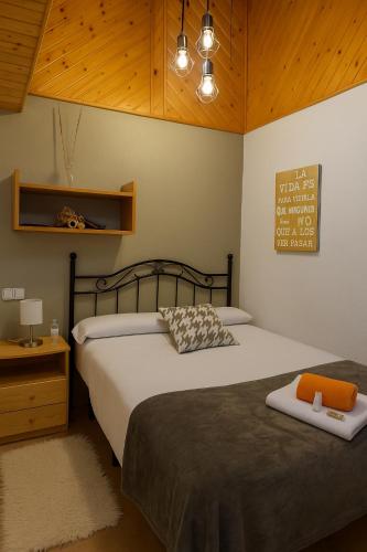 a bedroom with two beds and a wooden ceiling at Pensión O Muiño in O Pedrouzo