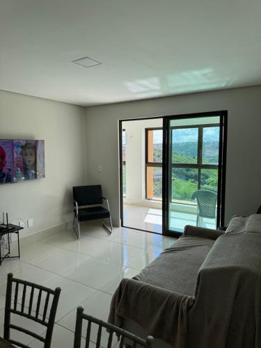 a bedroom with a bed and a sliding glass door at Alto da Serra Villas - Flat 301 in Bananeiras