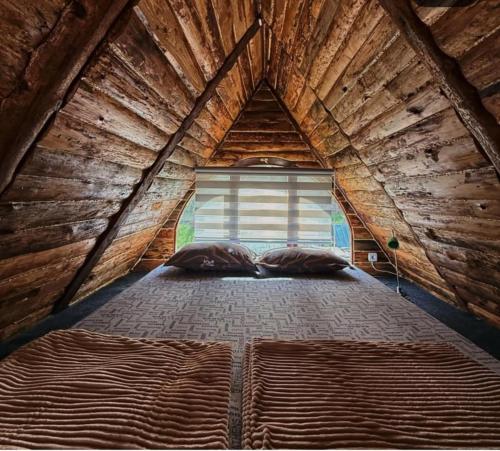 a large bed in a wooden room with a window at Dunavski Raj in Belgrade
