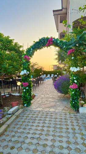 an arch covered in flowers on a patio at Sea Vista Hotel in Sveti Vlas