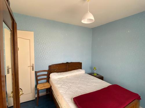 une petite chambre avec un lit et une chaise dans l'établissement Maison à 100 m de la plage, à Pirou