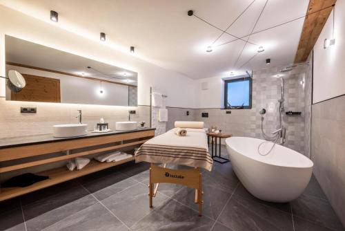 ein Badezimmer mit einer großen Badewanne und 2 Waschbecken in der Unterkunft MULIN Appartements in Vals