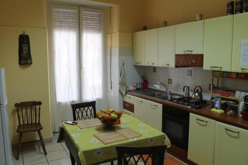 a kitchen with a table with a bowl of fruit on it at B&B Domus Pina in Catania