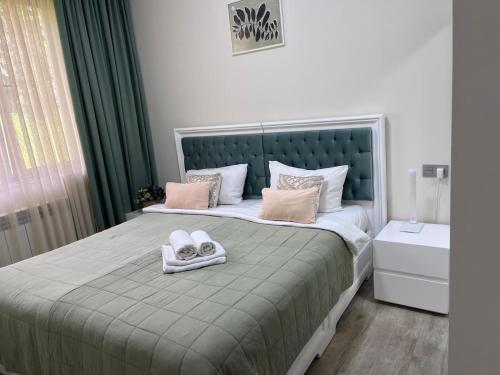 a bedroom with a bed with two towels on it at Guest House Botanical Paradise in Mtsvane Kontskhi