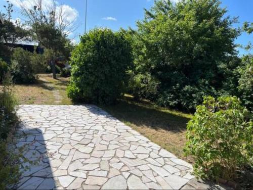 a stone walkway in a yard with bushes and trees at Summer Home with Private Garden in Klintehamn