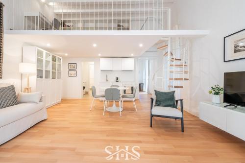 a living room with a couch and chairs and a kitchen at Domu Maria in Cagliari