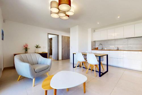 Il comprend une cuisine et un salon avec une table et une chaise. dans l'établissement Côté Jardin joli T2 avec garage à 100m du lac, à Annecy