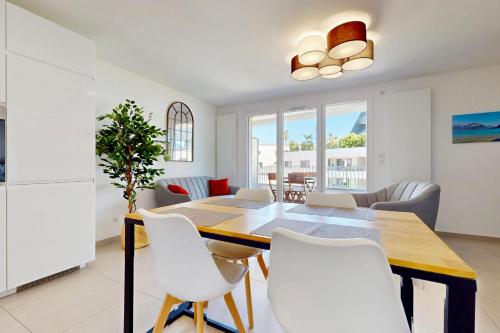 une salle à manger et un salon avec une table et des chaises dans l'établissement Côté Jardin joli T2 avec garage à 100m du lac, à Annecy