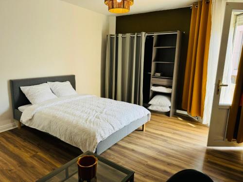 une chambre avec un lit et une table en verre dans l'établissement Pontlieu 24h Le Mans, au Mans