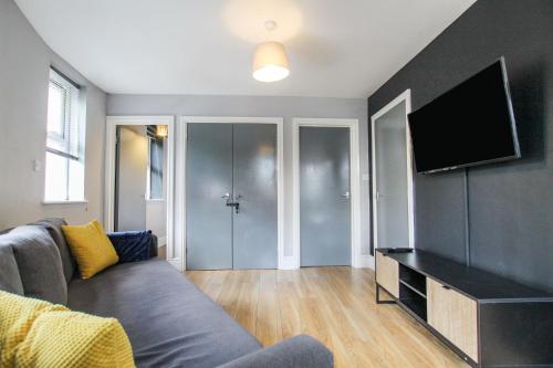 a living room with a couch and a flat screen tv at 2 Bedroom Property In City Centre by Prestige Lets in Bristol