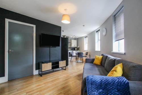 a living room with a couch and a flat screen tv at 2 Bedroom Property In City Centre by Prestige Lets in Bristol