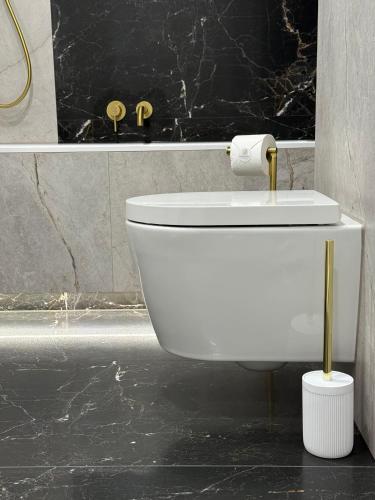 a white toilet in a bathroom with a black wall at GOLD Apartment - Lotnisko Katowice-Pyrzowice in Siewierz
