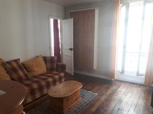 un salon avec un canapé et une table dans l'établissement Batignolles - Parisian appartment, à Paris