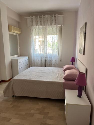 a bedroom with a large bed and a window at Aria di mare in Rimini