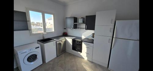 a kitchen with white appliances and a white refrigerator at AylinAylan in Ḩawmat al Badawīyīn