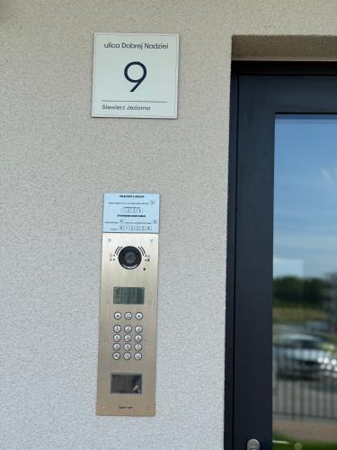 a remote control attached to a wall with a sign at GOLD Apartment - Lotnisko Katowice-Pyrzowice in Siewierz