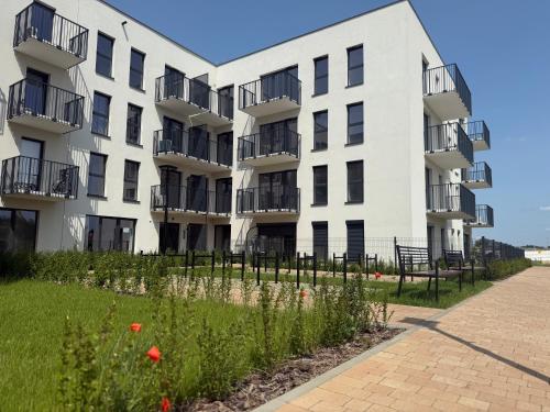 an apartment building with flowers in front of it at GOLD Apartment - Lotnisko Katowice-Pyrzowice in Siewierz