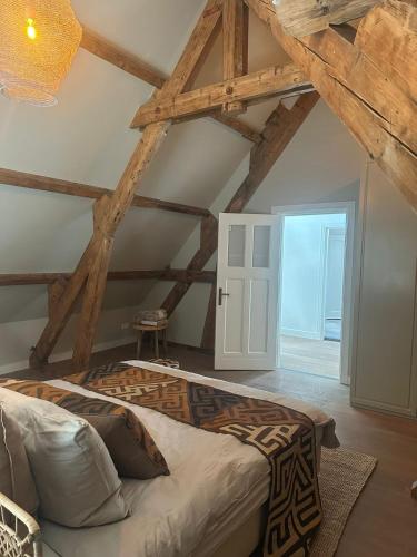 a bedroom with a large bed in a room with wooden ceilings at African Cosy suite in The Hague