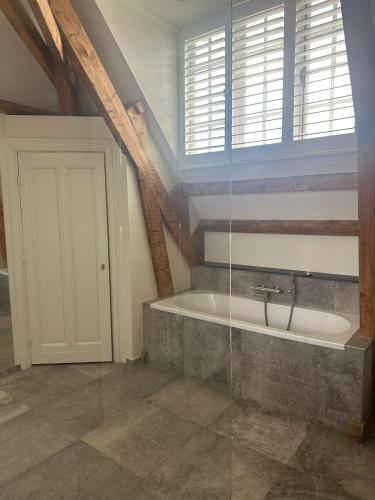 a bathroom with a bath tub in a attic at African Cosy suite in The Hague