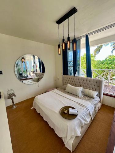 a bedroom with a large bed with a large window at Casa Arsha Beachfront Bed & Breakfast in Dzidzantún