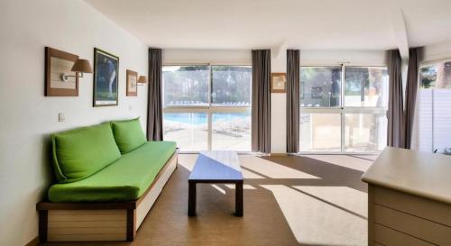 un salon avec un canapé vert et une table dans l'établissement Chez K&D by Laure, à Saint-Raphaël