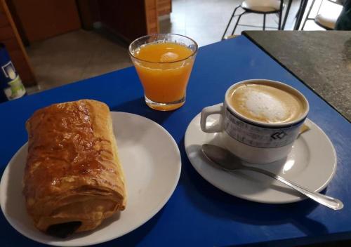a blue table with a plate of bread and a cup of coffee at Pensión O Muiño in O Pedrouzo