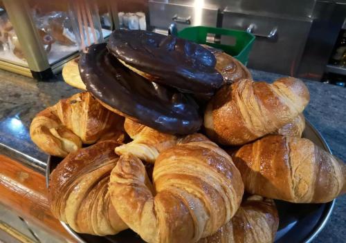 a plate of croissants and pastries on a counter at Pensión O Muiño in O Pedrouzo