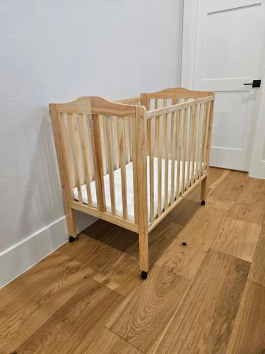a wooden crib in a room with a wooden floor at Roxell Ranch-A Country Retreat 12 Guests 6 beds in Brenham