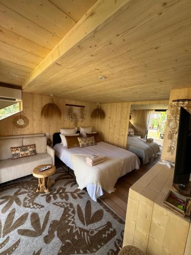 a bedroom with two beds and a couch at La Maison Du Soleil in La Garde-Freinet