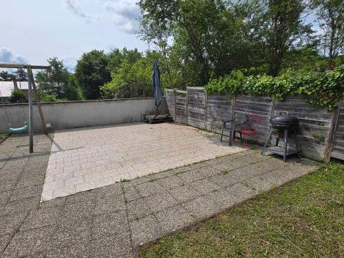 a patio with a grill and an umbrella next to a fence at Grande maison à Vendôme in Vendôme
