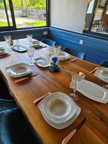 a wooden table with plates and glasses on it at Grande maison à Vendôme in Vendôme