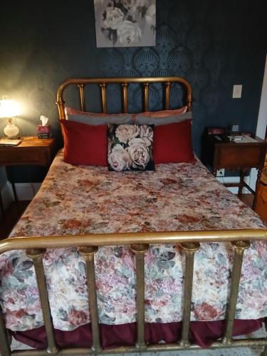 a bed with a floral bedspread and two pillows at The Bissing House in Hays