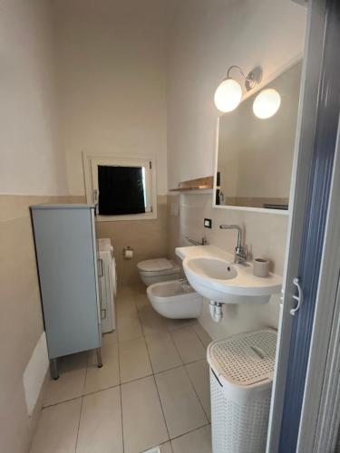 a bathroom with a sink and a toilet and a mirror at Casa Stella Residence Ea Bianca Baja Sardinia in Baja Sardinia