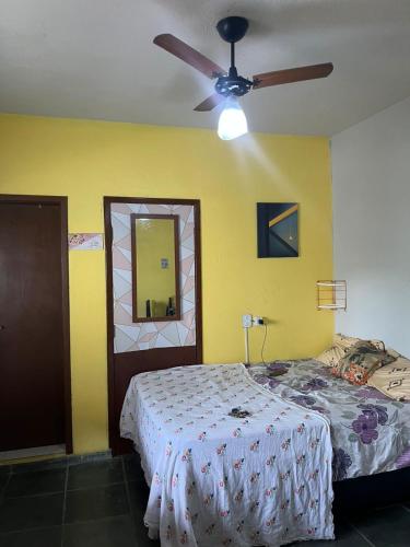 a bedroom with a bed and a ceiling fan at Viver a paz, praia & home office rua Nelson Pecegueiro do Amaral, 267, costa azul in Rio das Ostras