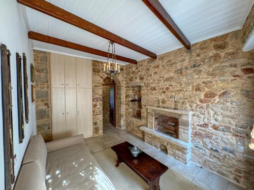 a living room with a stone wall with a fireplace at One&Only Kalamoti Gem Retreat in Kalamoti