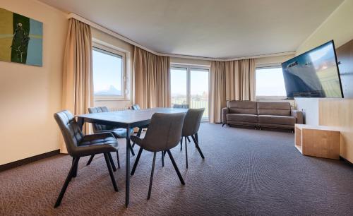 a room with a table and chairs and a couch at Momentum Hotel in Anif