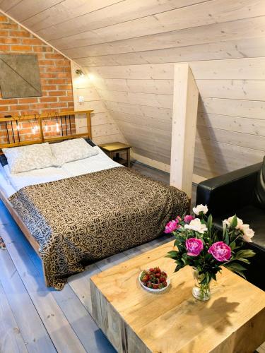 a bedroom with a bed and a table with flowers at Marychost- dom do wynajęcia in Kazimierz Dolny