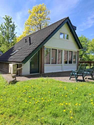a house with a bench in the grass at Heerlijk ! in Simpelveld