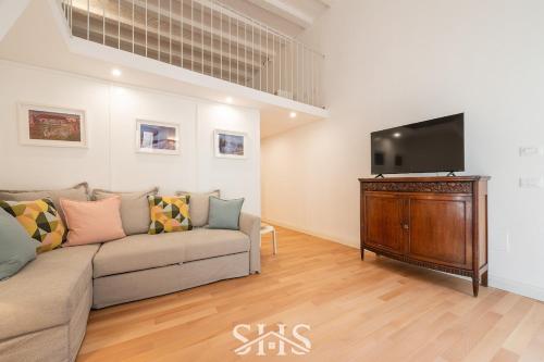 un soggiorno con divano e TV a schermo piatto di Domu Chiara a Cagliari