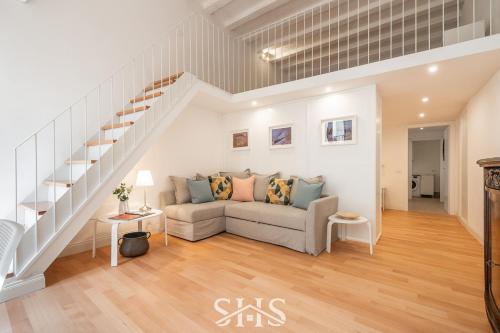 un soggiorno con divano e scale di Domu Chiara a Cagliari
