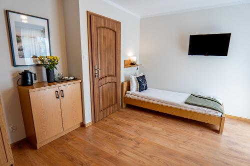 a bedroom with a bed and a wooden door at Noclegi Rezydent Polańczyk in Polańczyk